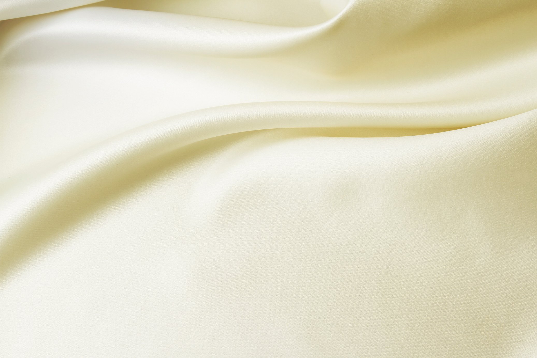 Ivory colored silk bedsheets with folds in the sheets